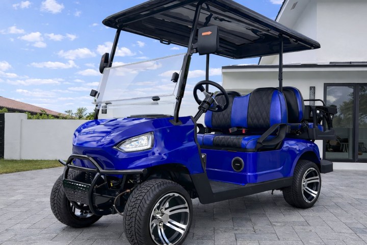 Blue, modern golf cart with black roof and seats parked on a driveway.